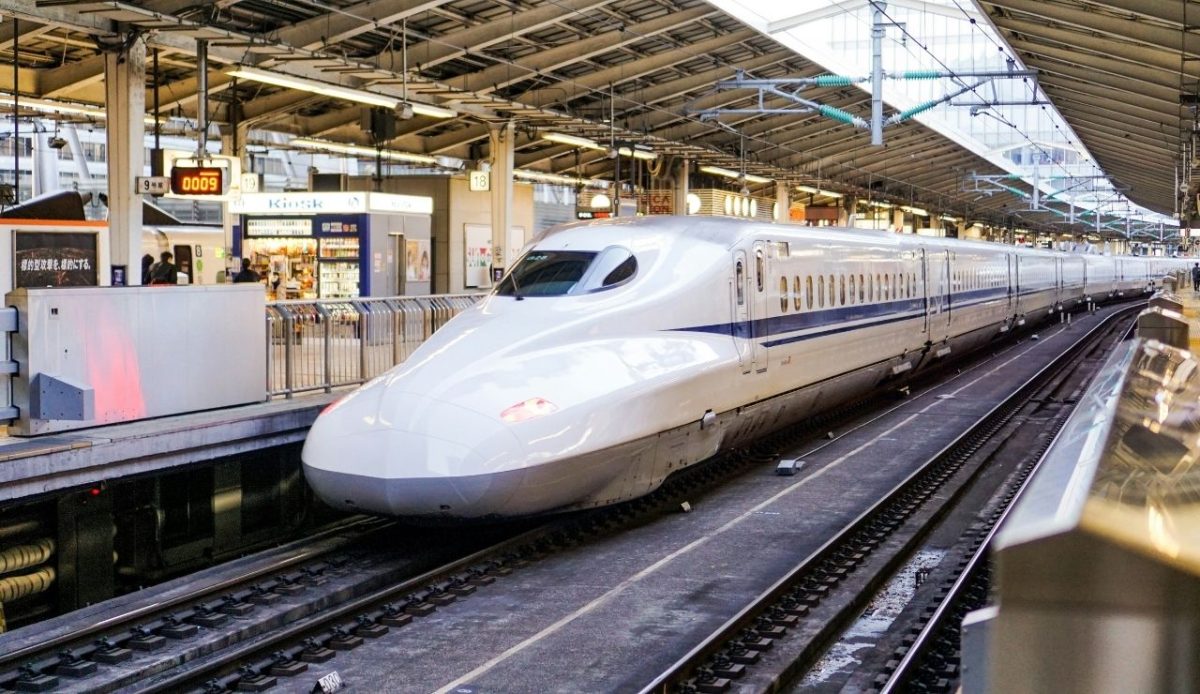 Japanese Shinkansen bullet train stopped at a station platform
