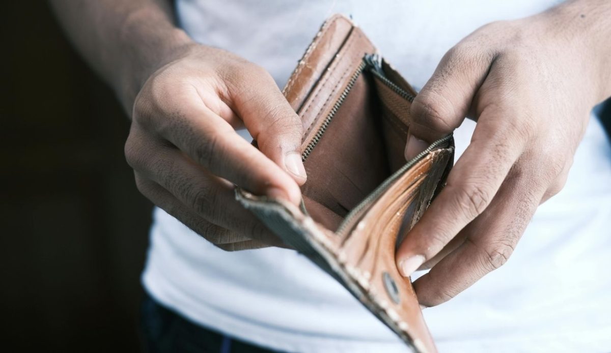 Person holding and opening an empty brown leather wallet
