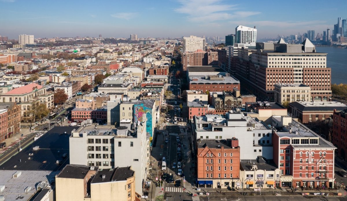 Aerial view of downtown Hoboken, New Jersey with buildings, streets, and the Hudson River 