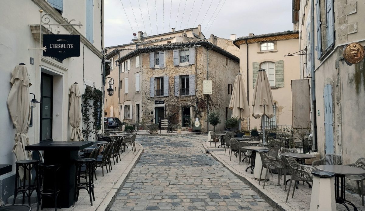 Cobblestone street with cafes and old buildings in a quaint French town 