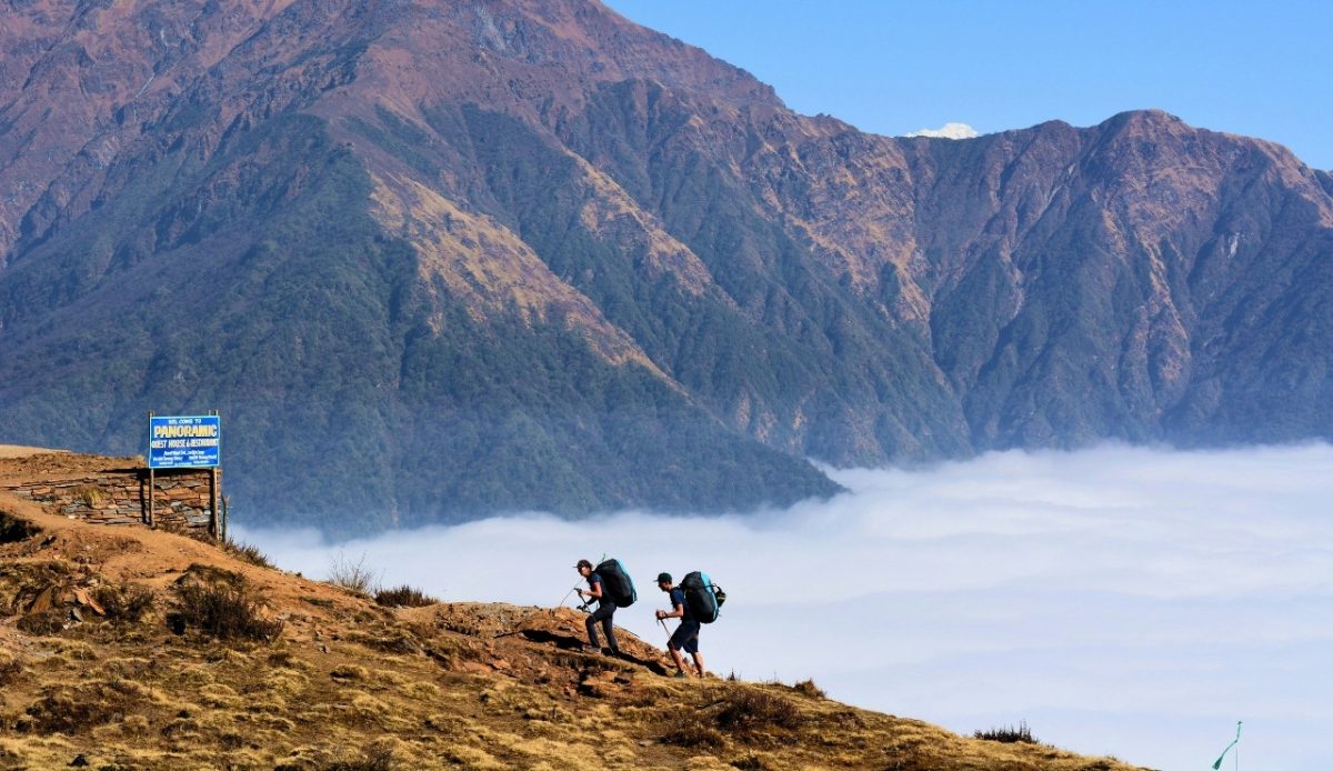12 Common Mistakes Travelers Make When Visiting National Parks 4 Hikers trekking on a mountain trail with a panoramic view of the valley below