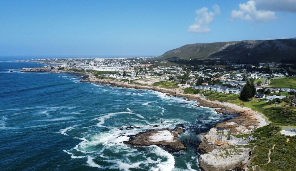 15 Small Towns in South Africa Travelers Should Visit Now 5 Aerial view of the coastal town of Hermanus, Western Cape, South Africa, with ocean waves crashing on the shore