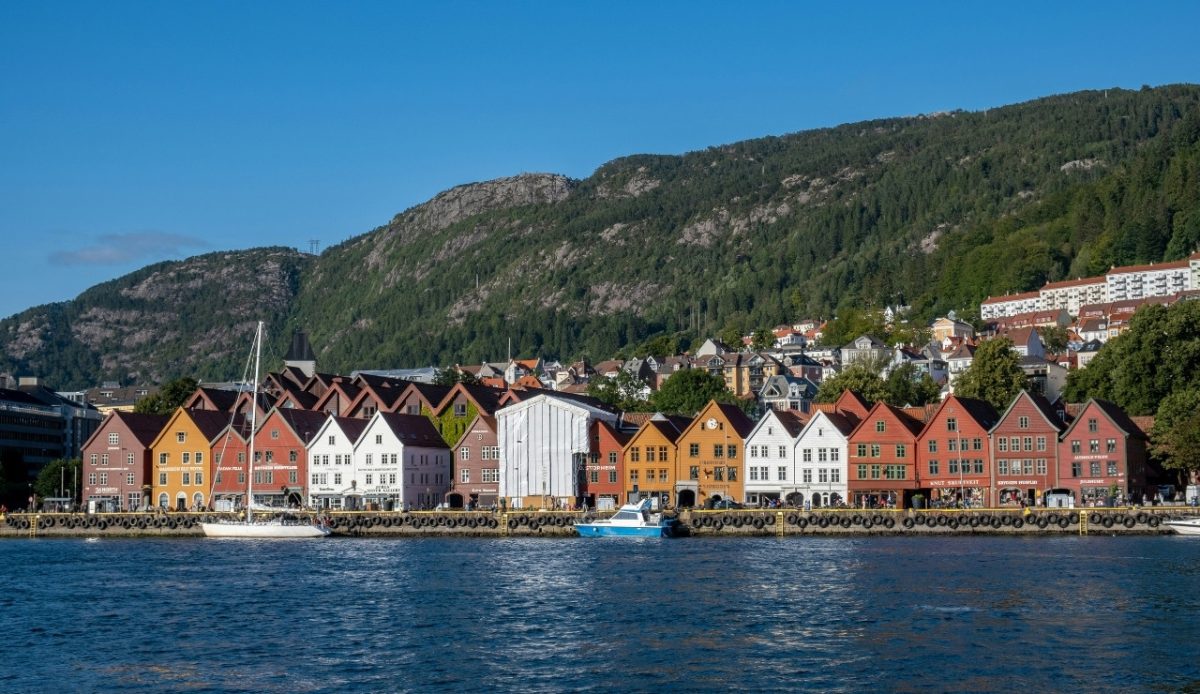 Colorful buildings along the harbor in Bergen, Norway with mountains in the background 