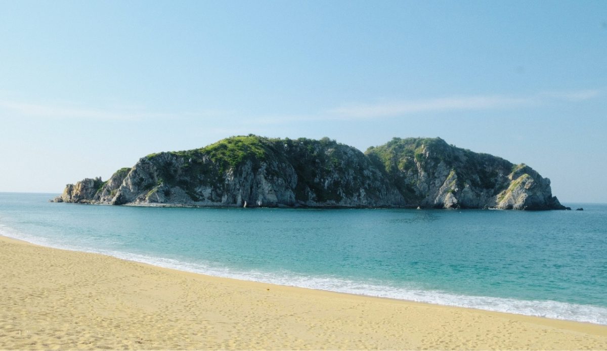 Huatulco, Oaxaca View of a secluded beach and rocky island in the clear blue water 
