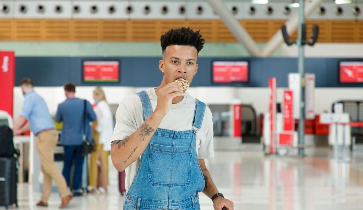 The Unspoken Rules of Airport Lounges and Why They Matter 2 A Man in a Denim Overall Eating a Cookie at an Airport