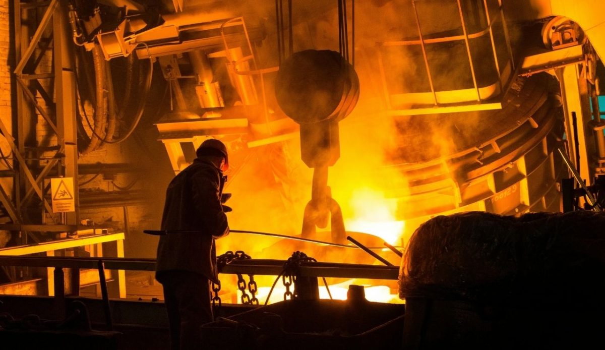 What Really Happens to Amtrak’s Old Trains After Retirement 2 A worker oversees molten metal being poured inside a steel foundry, with bright orange light reflecting off industrial machinery