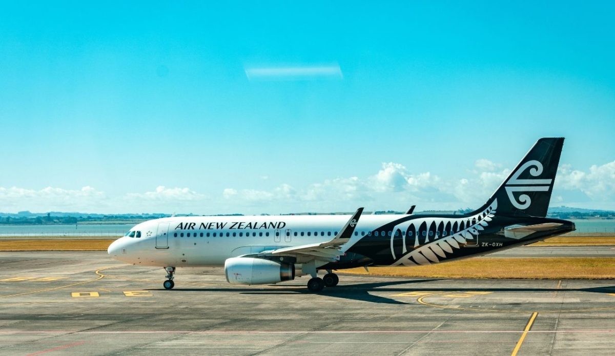 Air New Zealand Airbus A320 taxiing on runway with blue sky background