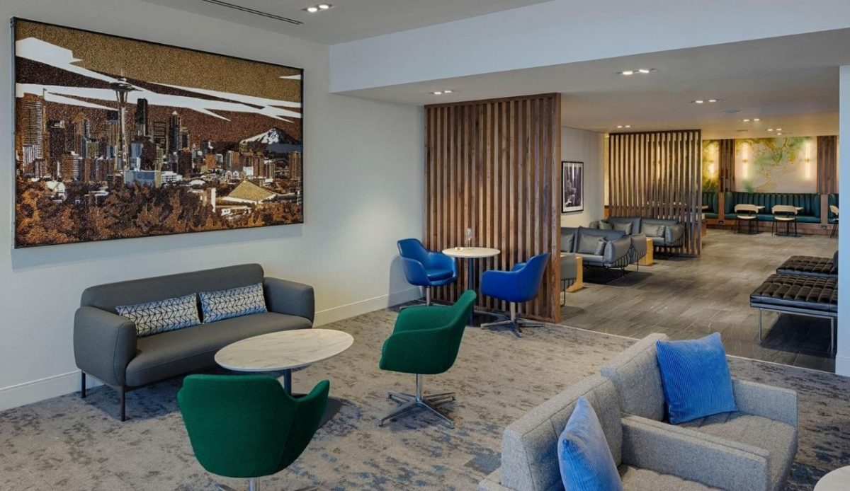 Amex airport lounge with seating areas, artwork, and warm lighting       