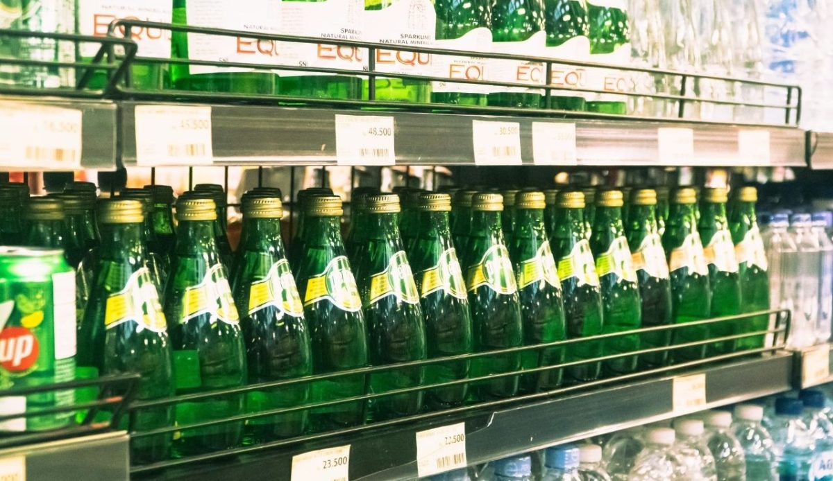 10 Things Never Worth Buying on a Cruise Ship or in Port 3 Bottles of sparkling water and soft drinks arranged on shelves in a grocery store beverage aisle
