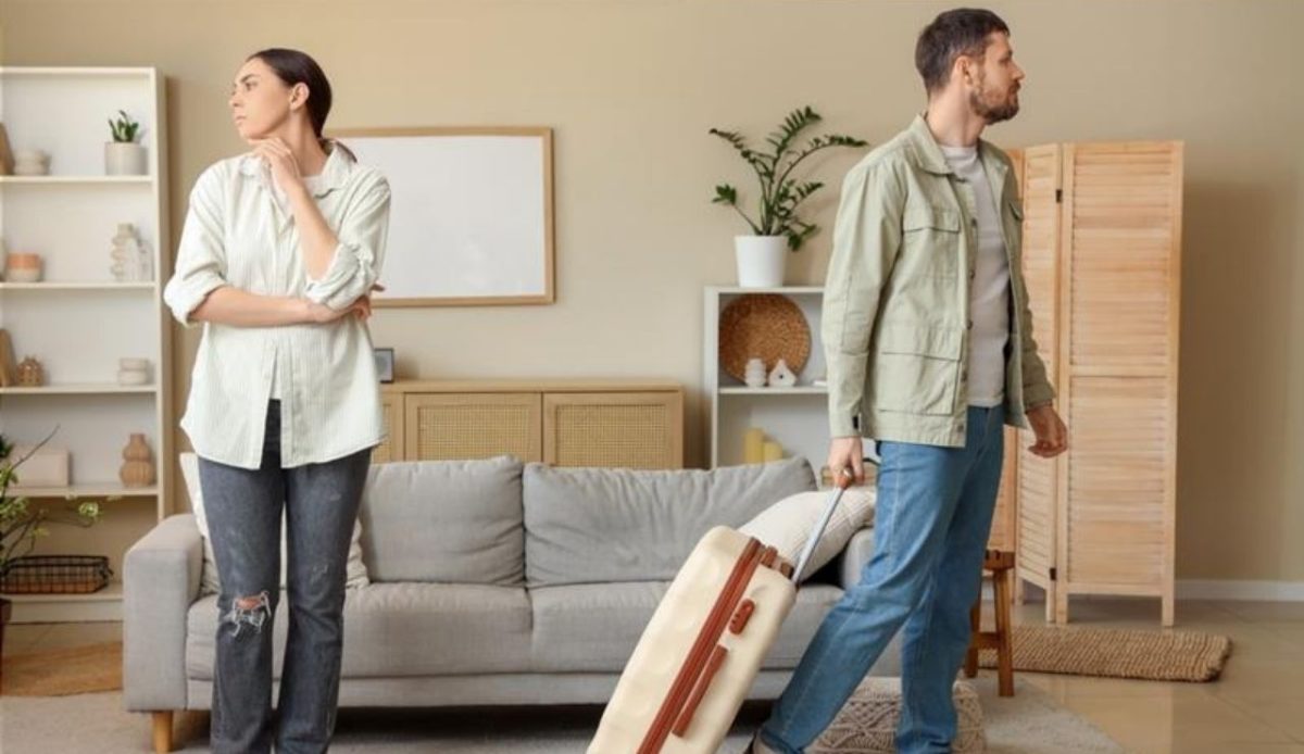 10 Reasons Travelers Sometimes Cancel Their Cruise Plans 8 Couple arguing at home as the man prepares to leave with luggage