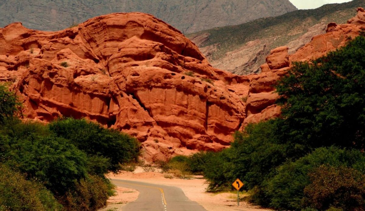 Curved desert road through red rock formations in Quebrada de las Conchas, Salta, Argentina