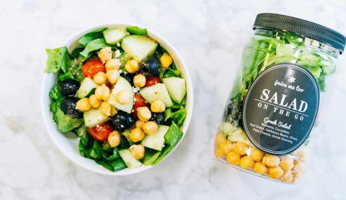 8 Airport Foods Every Traveler Should Avoid and Why 1 Greek salad with chickpeas, cucumbers, tomatoes, olives, and lettuce in a bowl beside a “Salad On The Go” jar on a marble countertop