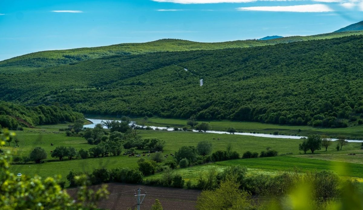 Green hills and farmland with a winding river near Deçan, western Kosovo 