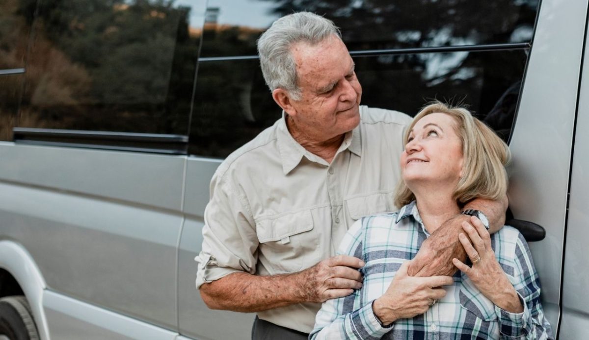 9 Reasons RVs Are Becoming America’s New Vacation Homes 6 Happy senior couple standing in front of rv