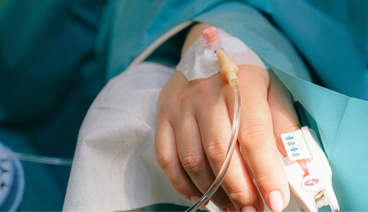 10 Reasons Travelers Sometimes Cancel Their Cruise Plans 1 Ill patient’s hand with IV line in hospital room, medical care setting