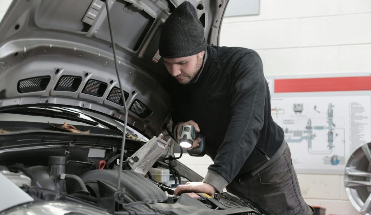 9 Road Trip Tips To Make Your Journey Fun And Memorable 2 Mechanic inspecting car engine with flashlight