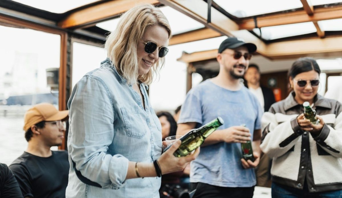 10 Things Never Worth Buying on a Cruise Ship or in Port 1 People holding Beer bottles in hands at Party