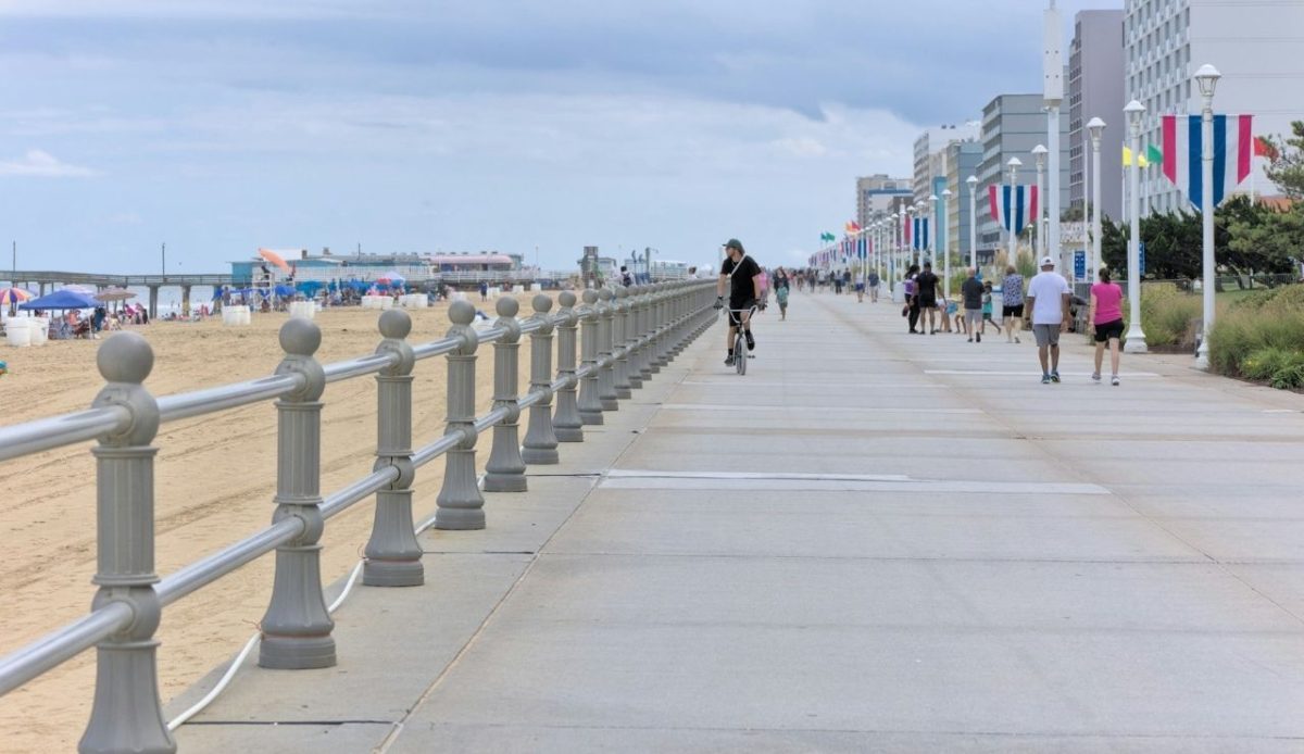 8 Famous East Coast Boardwalks and Beach Towns That Never Get Old 4 People biking and walking along the Virginia Beach boardwalk, Virginia, USA