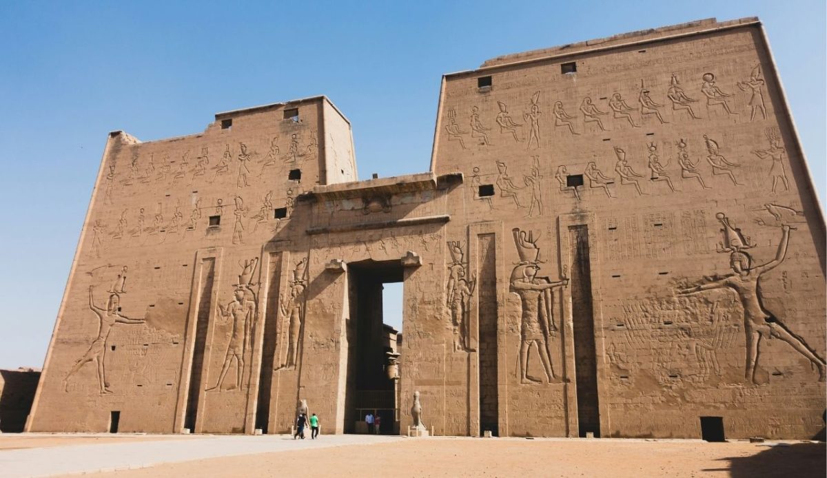 Temple of Edfu entrance with massive pylons and carved hieroglyphs, dedicated to the falcon god Horus