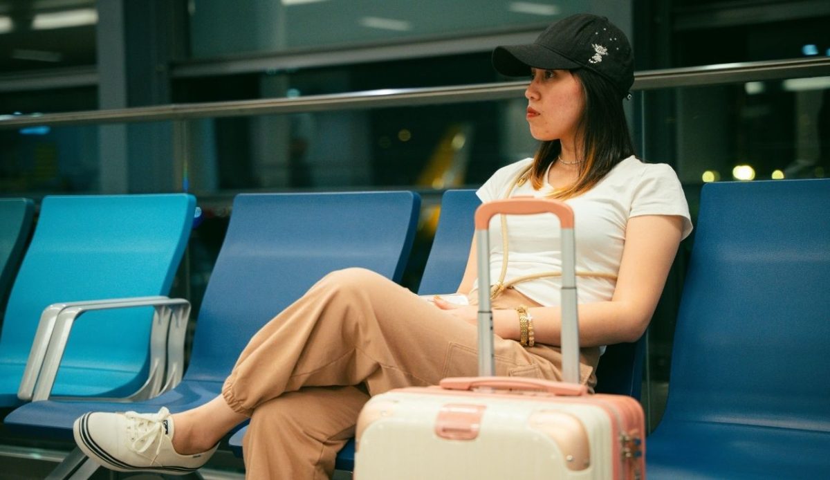 Woman at airport terminal waiting with luggage 