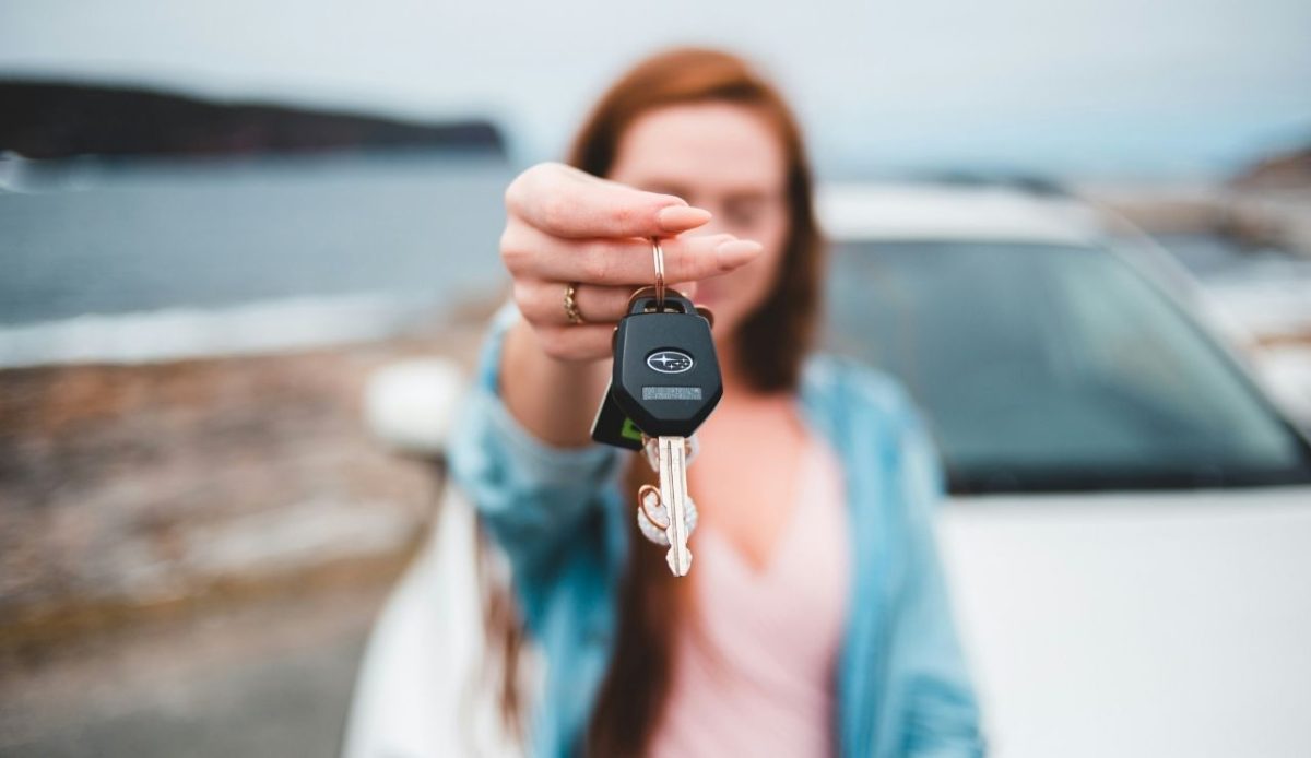 9 Road Trip Tips To Make Your Journey Fun And Memorable 4 Woman holding car keys near parked vehicle by the water