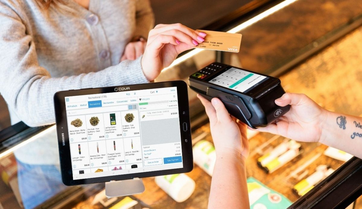 Woman paying with Visa card at checkout counter
