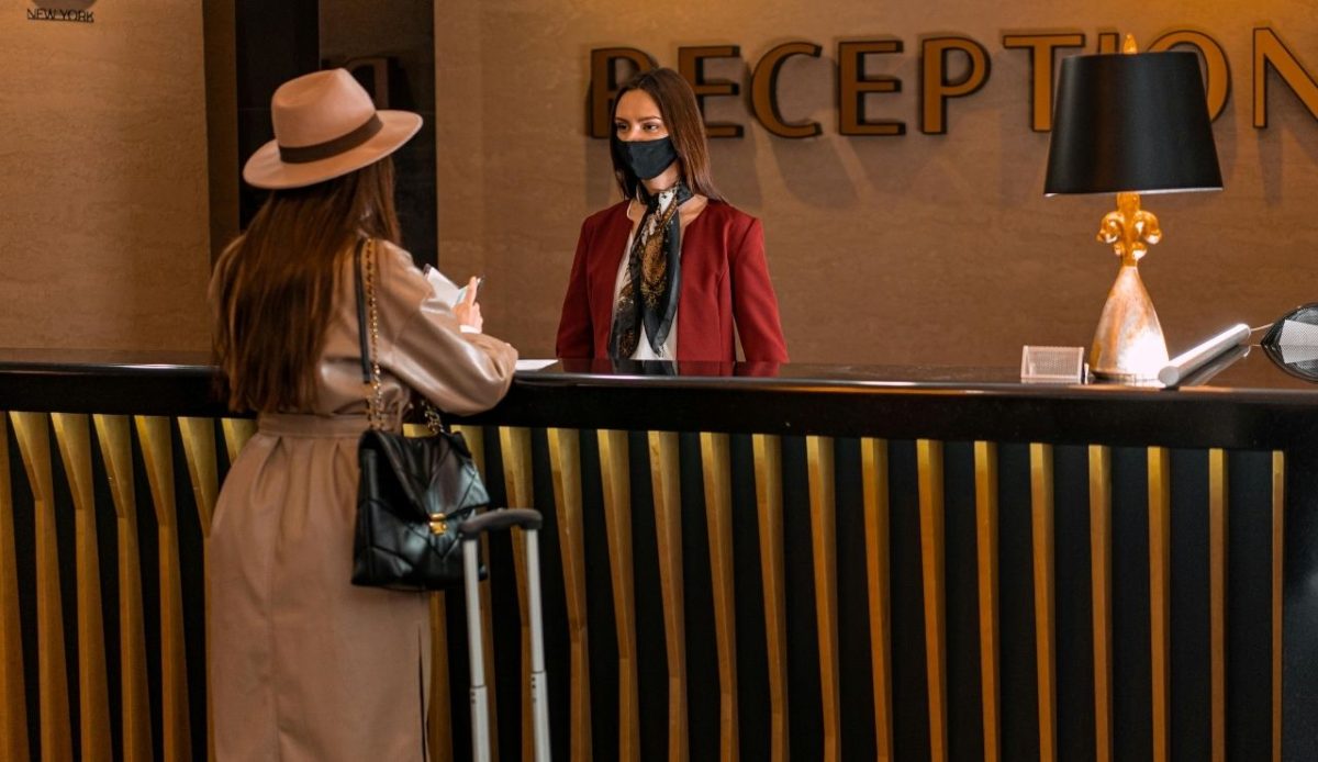 Women is talking with reception desk staff         