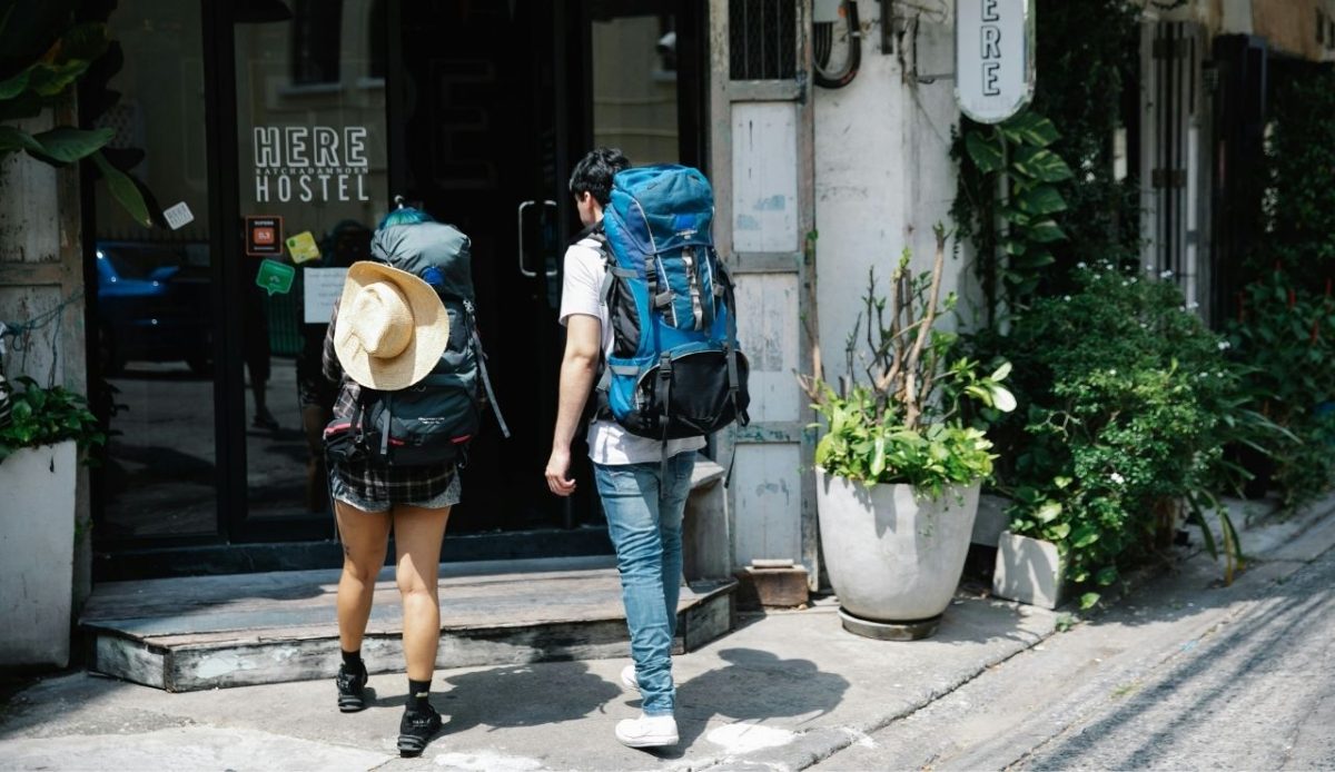 couple of travellers with backpacks entering hotel