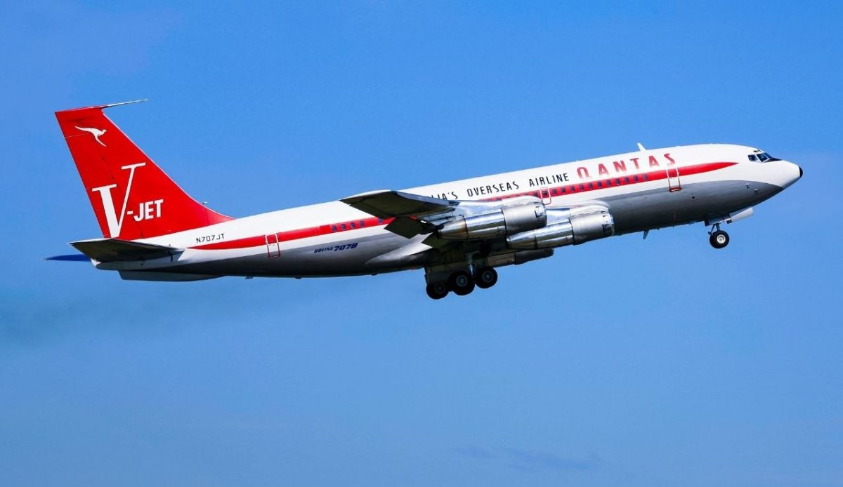Qantas Boeing 707 in retro livery taking off against blue sky