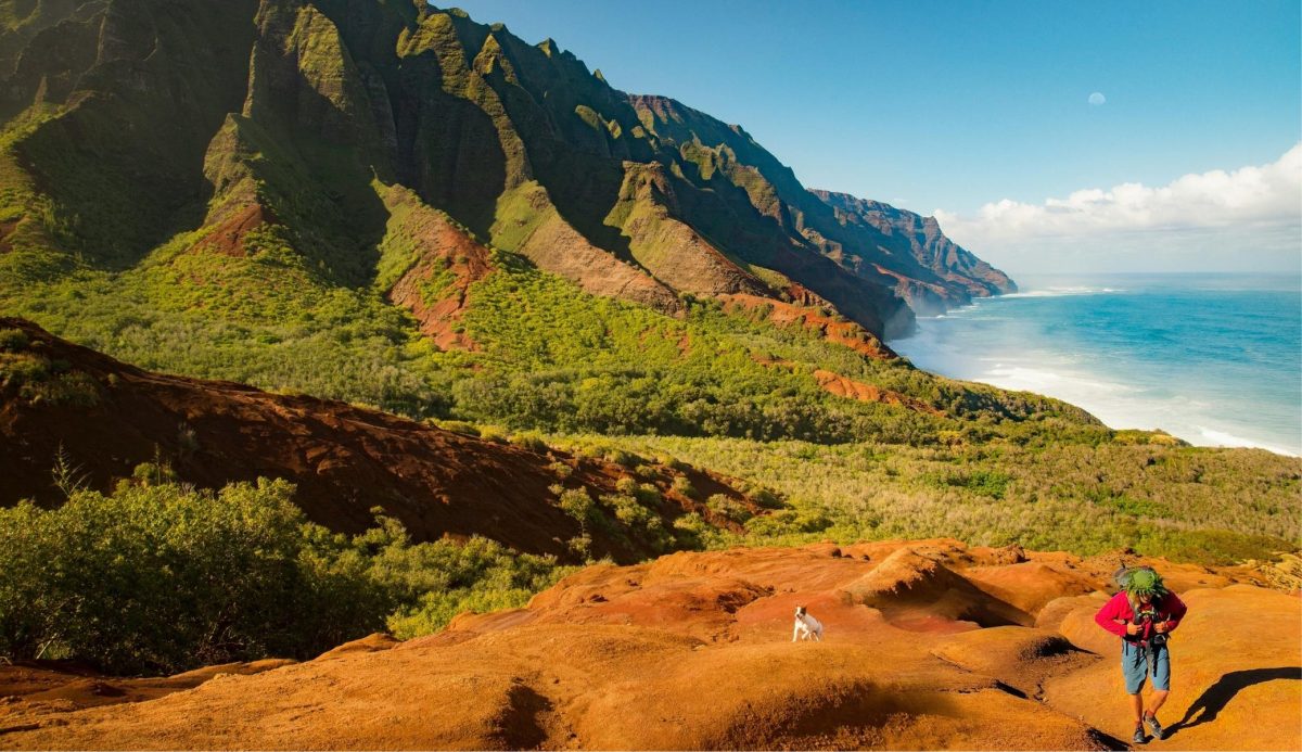 9 Best Hawaiian Islands to Visit for Every Kind of Traveler 3 Hiker on Kalalau Trail overlooking Nā Pali Coast in Kauai, Hawaii, USA