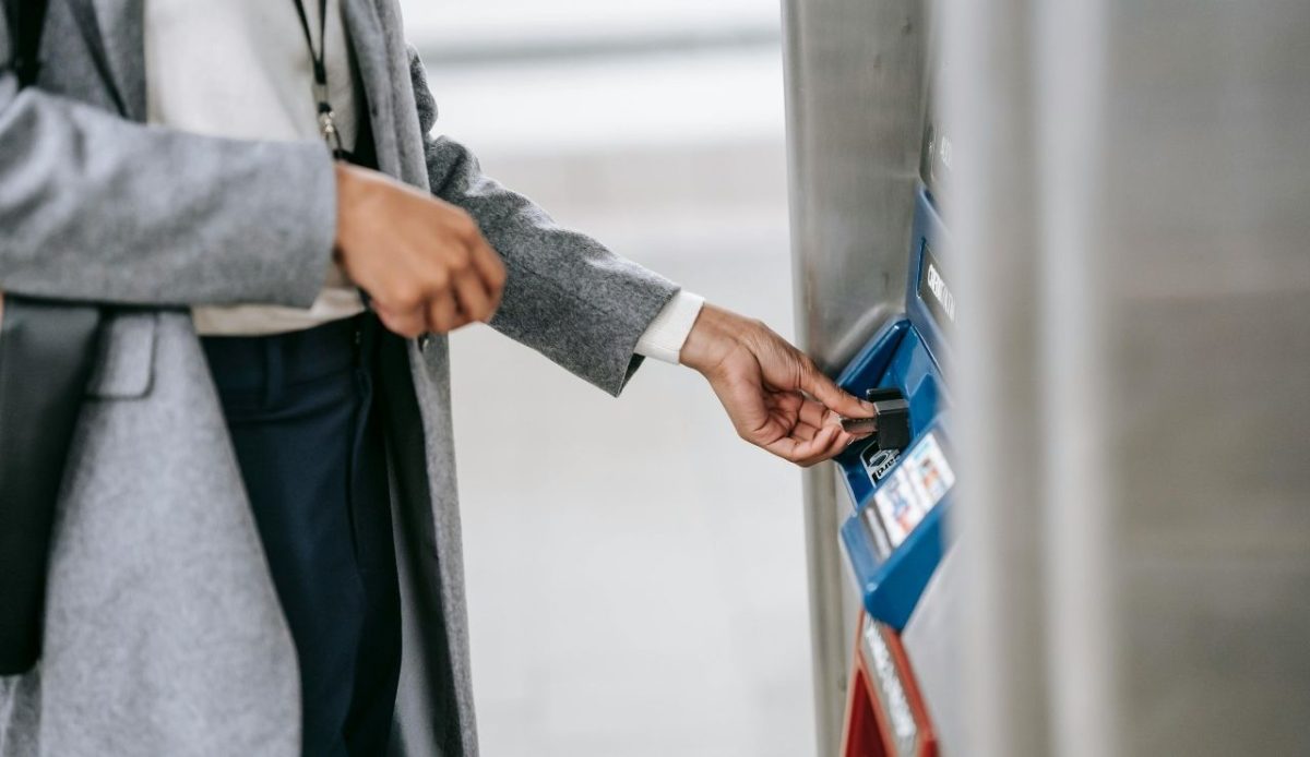 woman buying metro ticket via electronic machine