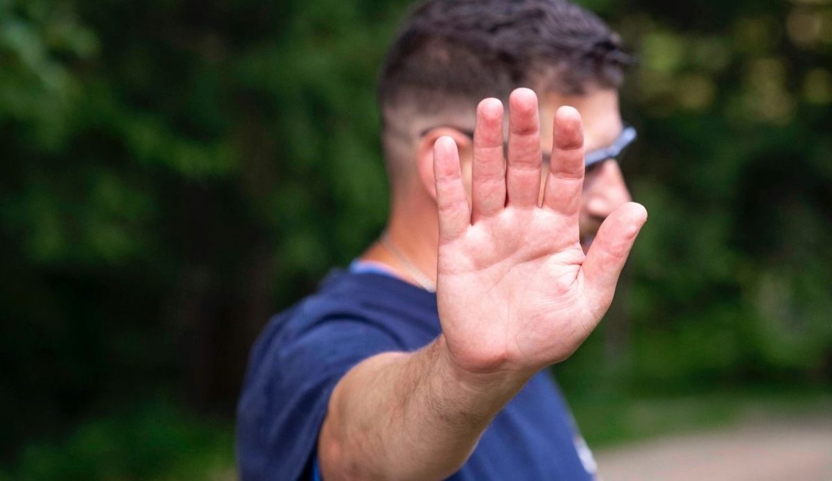 7 Common Phrases Americans Should Skip When Traveling Abroad 3 A person with a stop gesture