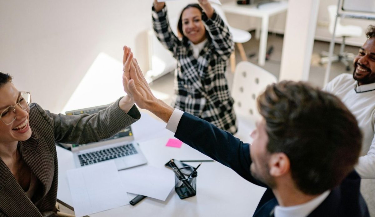 7 Common Phrases Americans Should Skip When Traveling Abroad 5 People high-fiving or smiling after achieving something