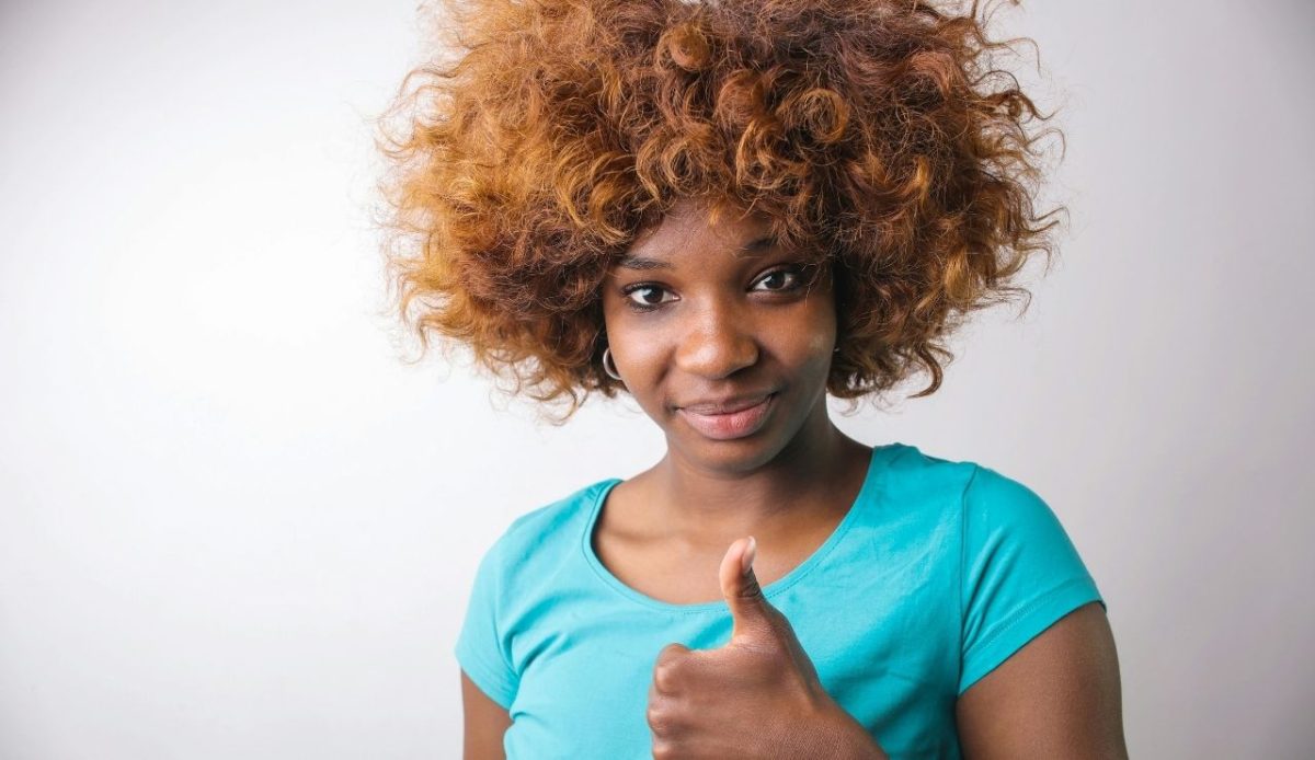 7 Common Phrases Americans Should Skip When Traveling Abroad 6 person smiling reassuringly or giving a calming gesture