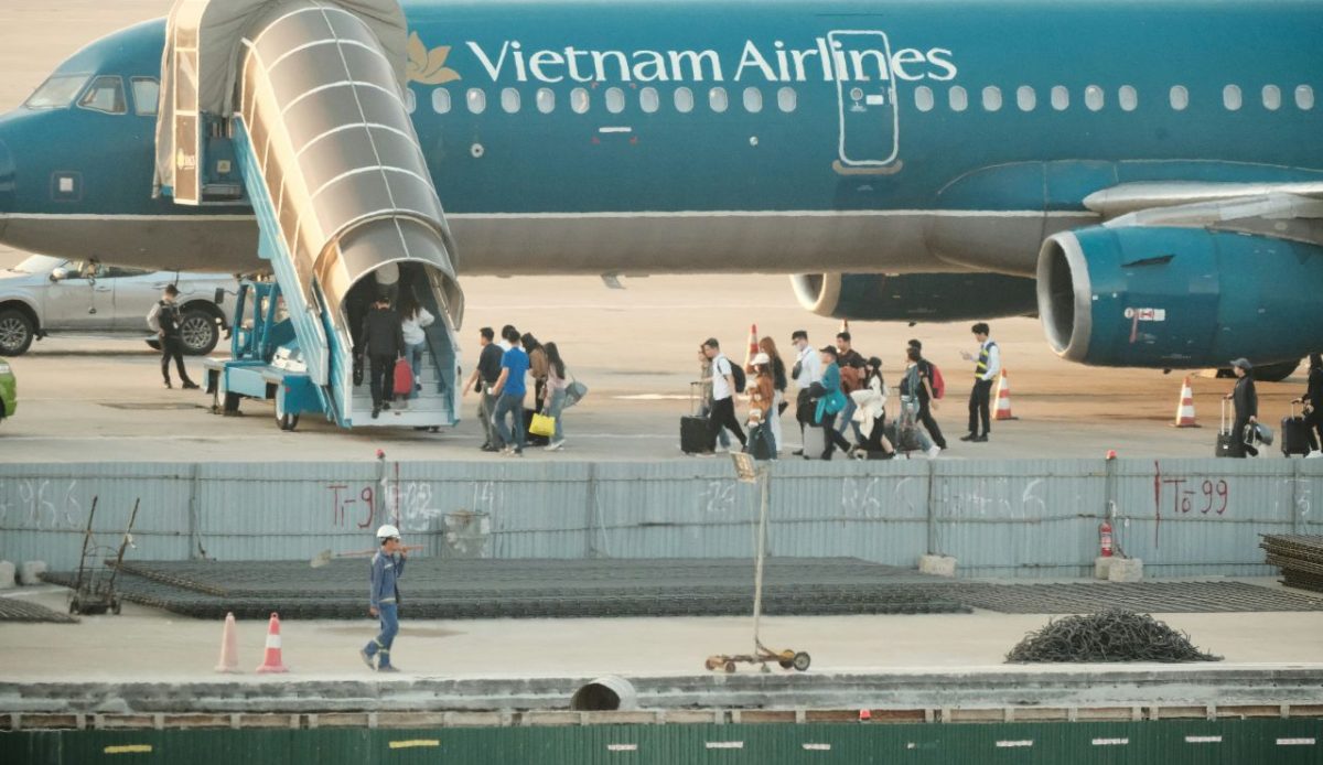 Passengers walking on tarmac to airplane         