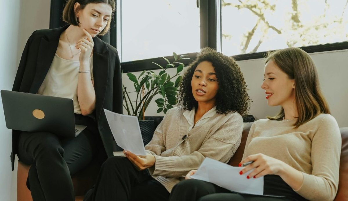 Women sitting on sofa reading cabin reviews for booking ,      