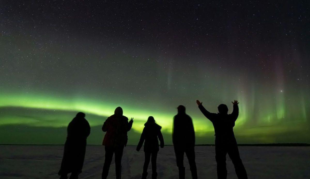 A group of people watching aurora  in night             