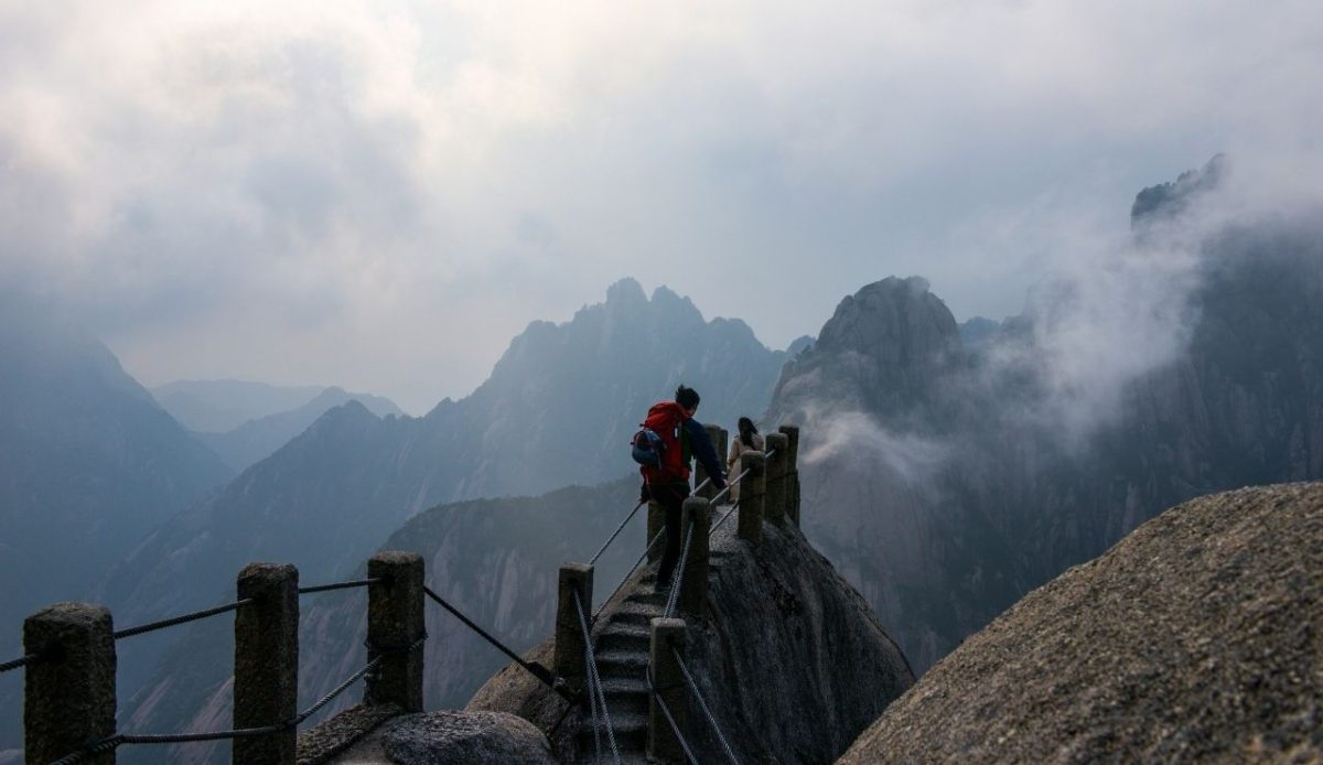 Hiker on misty mountain trail, Huangshan, Anhui, China            