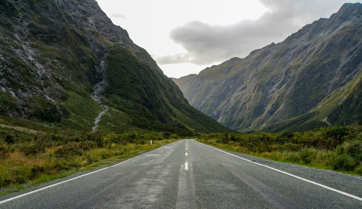 Milford Road stretching through steep mountain valleys in Fiordland, New Zealand                    