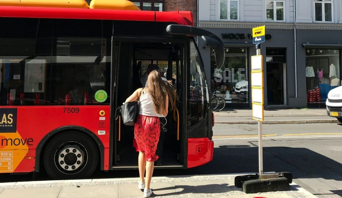 a woman is entering into public transport (bus)              