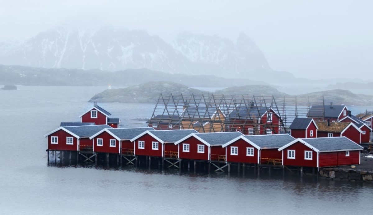 Red Norwegian cabins by the misty fjord, Norway       
