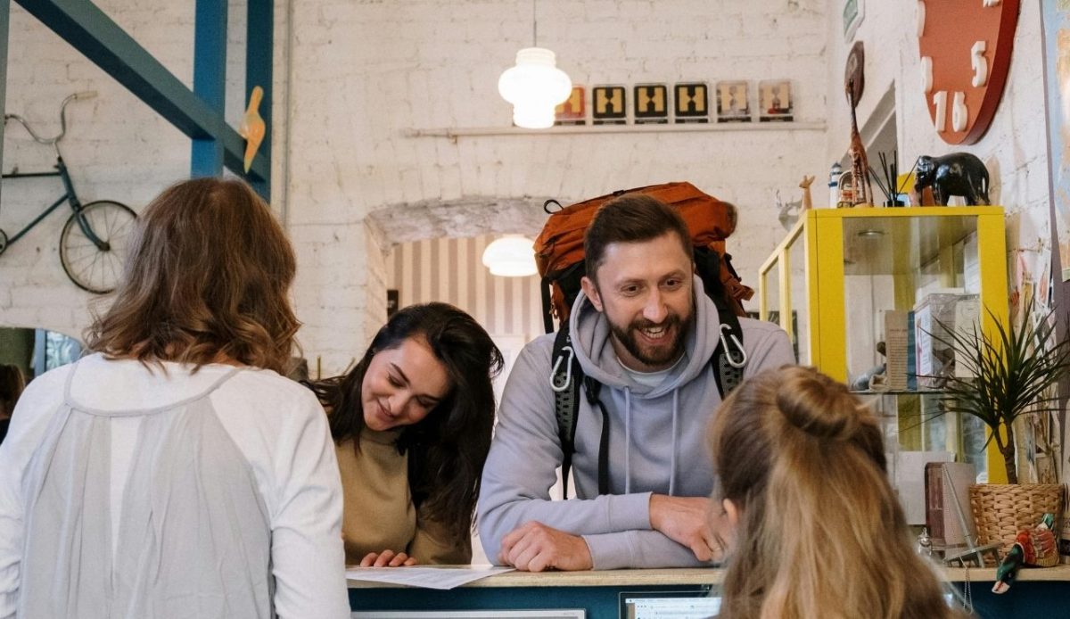 Smiling face of a Tourist Standing in front of Reception Desk                      