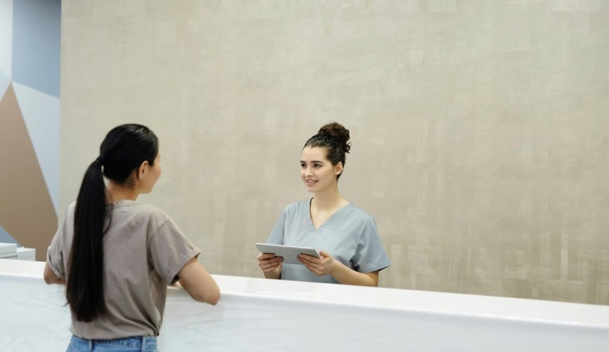 Nurse assisting a traveler at a clean medical desk, offering calm onboard health support   