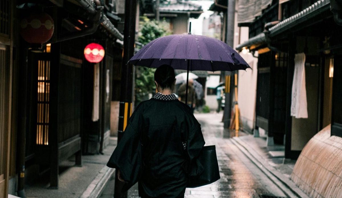 Woman Using Purple Umbrella Walking in the Street in rain   