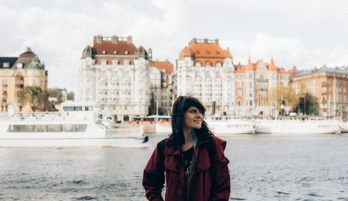 Woman in Red Jacket Standing Near Body of Water, Stockholm, Sweden