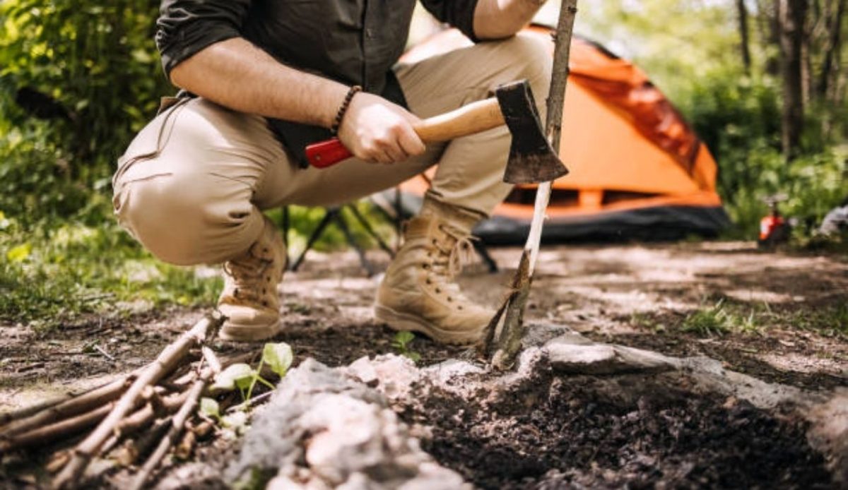 a tourist is cutting wood using axe    