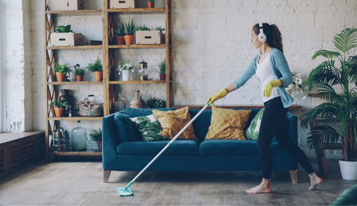 a women is Cleaning  room listening music                       