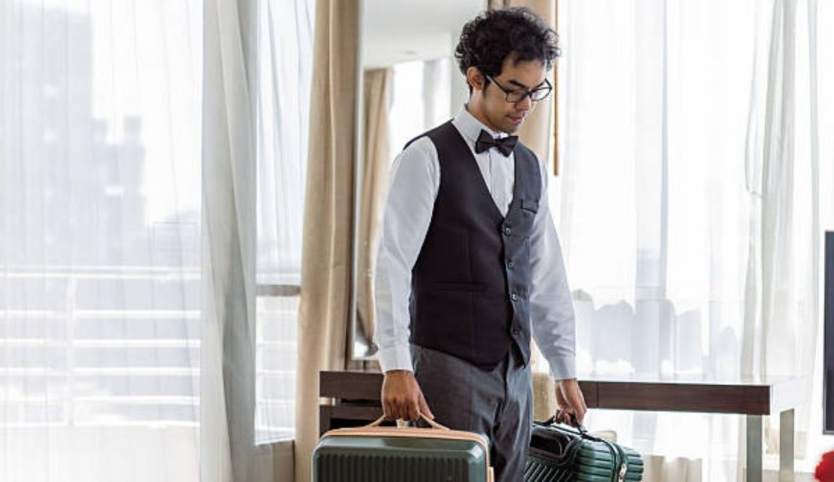 hotel waiter with suitcase in his hands                     
