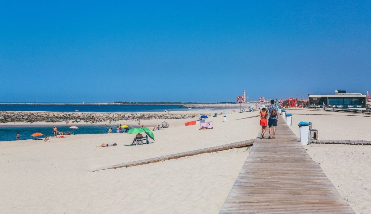 man and woman walking on wooden footbridge in Porto, Portugal             