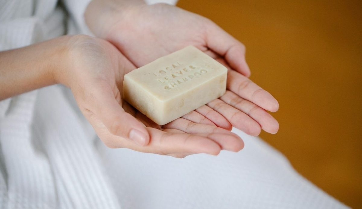 woman with natural shampoo bar (solid toiletries) in her hands       